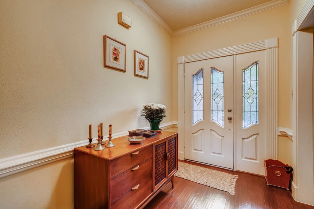 pexels-photo-8288959-8288959 A stylish entryway featuring a wooden sideboard, decor, and a classic front door.